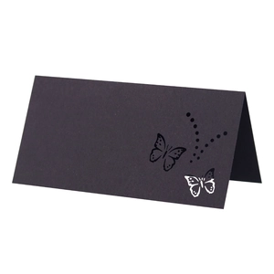Detail of laser-cut butterfly hollow pattern on black folded kraft paper place card