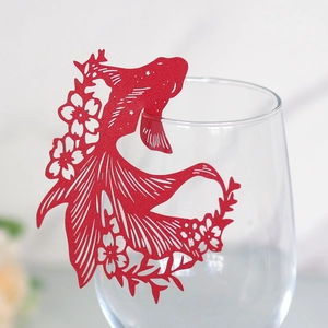 Detailed laser-cut red goldfish paper card with floral hollow patterns for wine glass decor