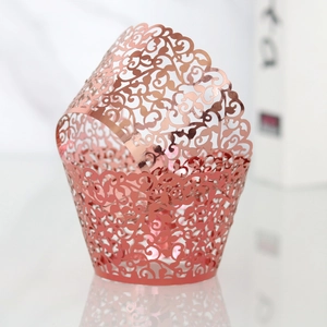 Detail view of rose gold laser-cut cupcake wrapper with intricate vine patterns