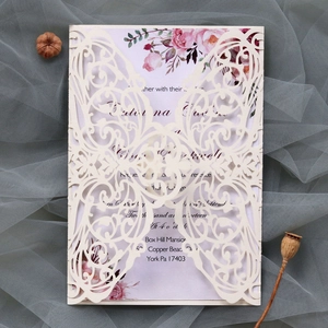 Detailed laser-cut pattern on white wedding invitation with floral insert card