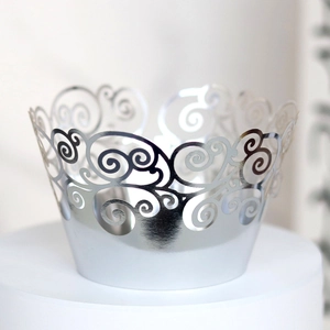 Macro shot of silver hollow-out laser cut cupcake liners with elegant swirl patterns