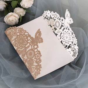 Detail of laser-cut rose gold glitter wedding invitation with butterfly and flower patterns