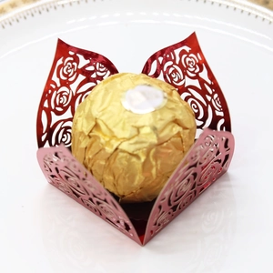 Close-up of laser-cut red rose pattern paper wrap for chocolate wedding favors