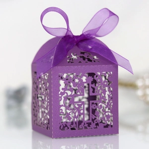 Detail of purple laser-cut wedding favor box with ornate vines and ribbon bow