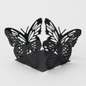 Detail of black laser-cut butterfly wedding favor box with intricate hollow design