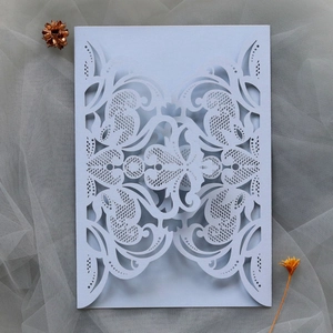 Macro detail of laser-cut lace pattern on light blue wedding invitation sleeve