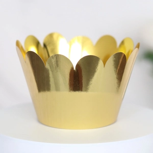 Close-up of laser-cut crown shape cupcake wrapper in shiny gold mirror finish for party
