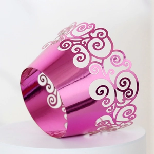 Close-up of laser-cut metallic purple cupcake wrappers with hollow cloud patterns