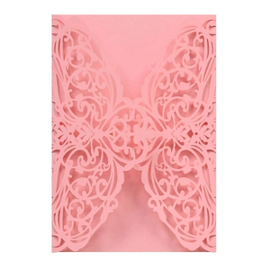 Detail of pink laser-cut butterfly and floral patterns on an elegant wedding invitation
