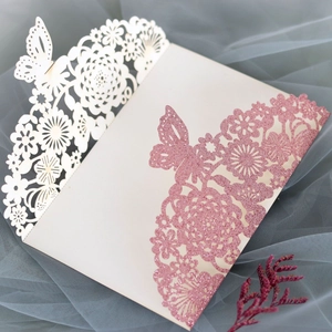 Close-up of glitter pink rose and butterfly laser cut wedding invitation card detail