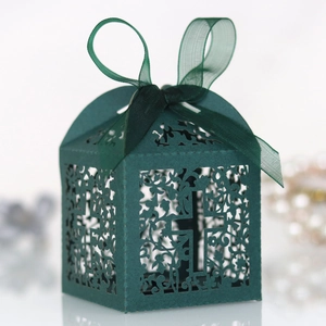 Detail of laser-cut dark green favor box with cross design and organza ribbon