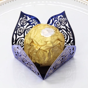 Deep blue laser-cut rose hollow favor box with gold foil chocolate on white porcelain
