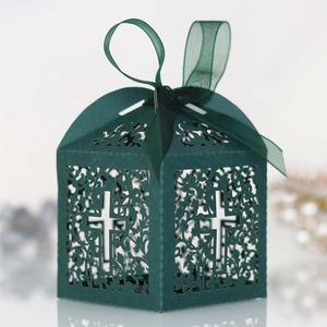 Detail of dark green hollow laser-cut gift box with elegant cross pattern and ribbon