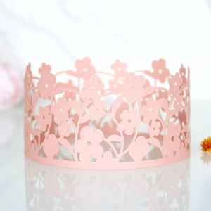 Elegant laser-cut pink flower paper cake wrap with intricate floral patterns for party