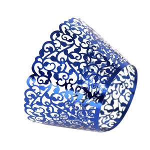 Close-up of laser-cut vine patterns on metallic blue cupcake wrappers for party decor