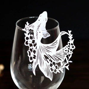 Intricate laser-cut fish wine glass card with elegant floral hollow details for weddings