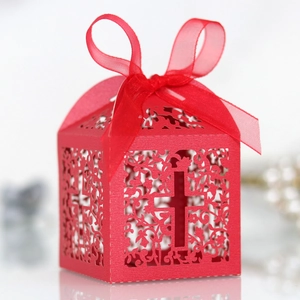 Macro shot of red laser-cut candy box with cross pattern and elegant organza ribbon bow