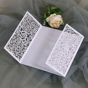 Detailed laser-cut rose and vine pattern on a white tri-fold wedding invitation card