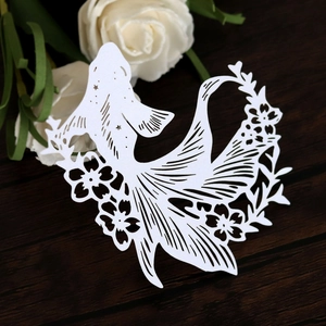 Detail of white hollowed-out fish and cherry blossom paper card for wine glass decor