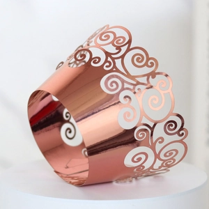 Detailed close-up of rose gold laser-cut cupcake wrappers with mirror finish and scrolls
