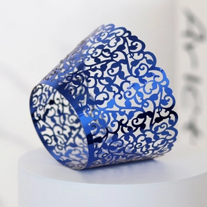 Macro shot of laser-cut vine patterns on metallic blue cupcake wrappers for parties