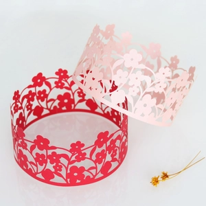 Laser-cut floral cake wrappers in red and pink with intricate vine patterns for decoration