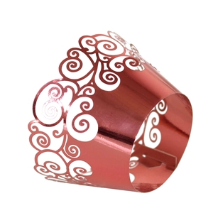 Detail of rose gold laser-cut cupcake wrappers with elegant baroque scroll patterns