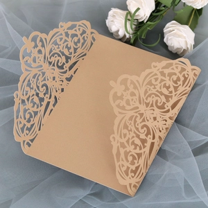 Macro shot of laser-cut floral patterns on a champagne gold wedding invitation card