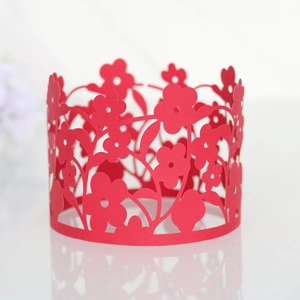 Macro shot of red laser-cut floral lace paper wrappers for wedding cake decorations
