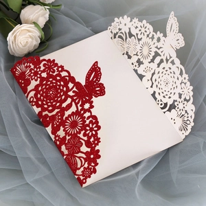 Detail of laser-cut wedding invitation with red glitter butterfly and floral pattern
