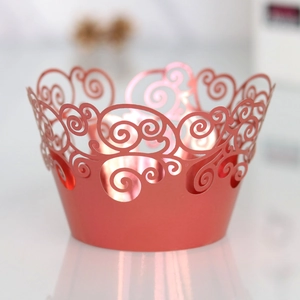 Close-up of rose gold laser-cut cupcake wrappers with elegant scroll patterns