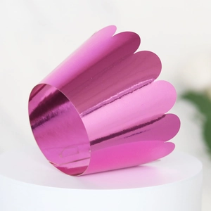 Detailed view of metallic rose pink laser-cut cupcake wrapper with scalloped edges