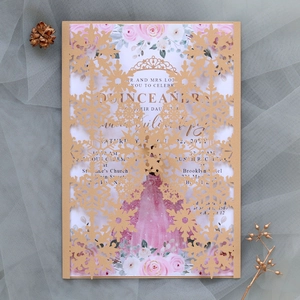 Macro detail of laser-cut snowflake invitation with gold pearlescent finish and floral insert