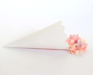 Detail of white wave-edged kraft paper confetti cone with pink dried flower petals