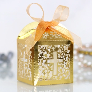 Detailed laser-cut gold wedding favor box with hollow cross design and orange ribbon