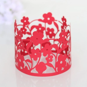 Macro shot of red laser-cut floral cupcake wrappers and hollow paper cake borders