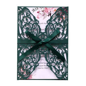 Detail of dark green laser cut butterfly wedding invitation with elegant silk ribbon