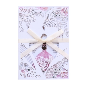 Close-up of laser-cut wedding invitation with rose silhouette and silk ribbon bow