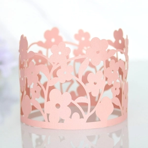 Close-up of pink laser-cut floral paper cake wrap for elegant birthday party decorations