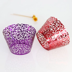 Laser-cut paper cupcake wrappers featuring elegant vine patterns in purple and red colors