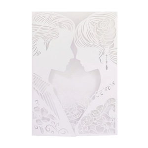 Close-up of laser-cut wedding invitation featuring a romantic couple heart and rose lace