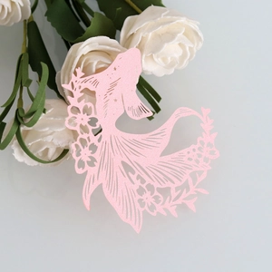 Intricate laser-cut pink koi fish paper decoration with pearlescent floral details