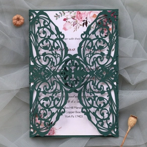 Detail of dark green laser-cut wedding invitation with elegant pink floral inner card
