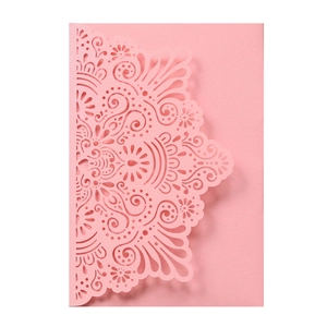 Macro view of laser-cut pink wedding invitation with intricate mandala patterns