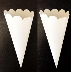 Close-up of white wave-edged paper cones for wedding confetti or party petals