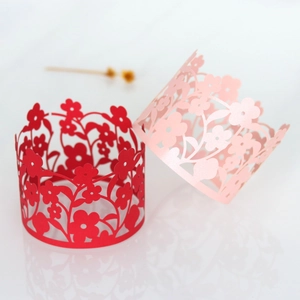 Detail of red and pink laser-cut floral hollow paper cake borders and napkin rings