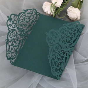 Close-up of laser-cut emerald green floral invitation card with intricate lace details