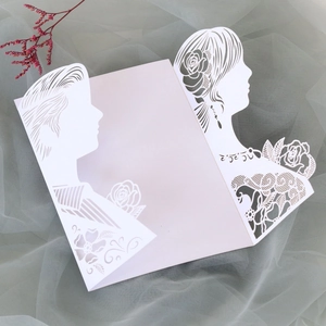 Detailed laser-cut wedding invitation featuring bride and groom silhouettes on lace paper