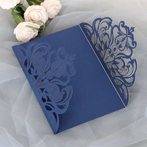 Detailed laser-cut vine patterns on navy blue pearlescent paper invitation cover