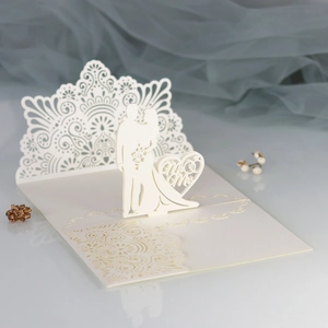 Detailed laser-cut wedding card with Mr & Mrs silhouette and intricate lace pattern